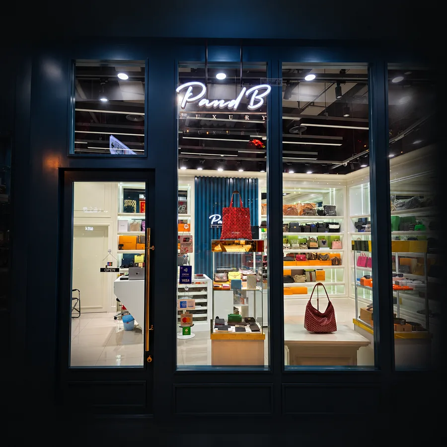 หน้าร้าน P and B Luxury ตอนกลางคืน มองเห็นกระเป๋าแบรนด์เนมในร้าน